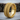Close-up of the intricate repeating geometric band design on the biomechanical ring resting on a textured wooden stump