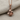 Stemmed Rose Pendant, rose gold, front view on textured fabric