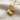 Close-up of the handcrafted tiny boot pendant in premium 925 sterling silver resting on textured fabric