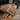 Man wearing the rugged oxidized silver Carry The Boats signet ring on his hand resting on a wood table