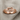 Close-up of polished infinity knot ring resting on textured linen fabric showcasing detailed craftsmanship