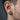 Lifestyle side profile shot of men's two-tone wolf stud earring worn on the earlobe showing rich detail