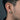Close-up profile of a man wearing the oxidized silver Roman eagle earring showing the two-tone stud detail