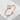 Great wave crest ring, rose gold, angled view on stone base