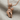 Microphone Fist Pendant, rose gold finish, angled view on linen fabric