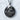 Close-up of vintage style Saint Nicholas medallion pendant in oxidized silver resting against a textured white wall