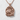 Nestled Rabbit Pendant, rose gold, front view on textured background