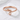 Dragon wrap ring, rose gold, front view on textured white surface