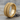 Biomechanical Gear Band Ring in gold vermeil, front view on wood surface
