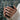 Handheld view of a classic Claddagh ring worn on finger while holding a mug in cozy winter knitwear