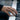 Clasped skeleton hands ring worn on finger in daily wear lifestyle setup over piano keyboard keys