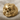 Skull and Roses Ring, gold vermeil, front view on fabric background
