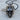 Middle Finger Skull Pendant, black rhodium, front view on wood