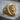 Scroll Jesus Christ Ring, gold vermeil, three-quarter view on wood