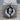 Baby Foot in Hands Pendant, oxidized silver, front product view on wood