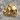 Baroque Scroll Skull Ring in gold vermeil, front view on stone surface