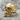 Anatomical cracked skull ring, gold vermeil, three-quarter view on rock