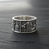 Front view of silver playing card ring on dark slate showing detailed King and Queen of Spades panel engravings