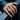 Person wearing the handcrafted Sacred Heart Jesus ring in gold vermeil resting hand on a black metal railing