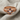 Close-up of handcrafted orthodox cross ring resting on fabric, detailing the raised prayer letters and gem settings.