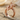 Premium 925 sterling silver twin giraffe ring featuring rose gold plating resting elegantly on textured sand.