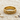 Beautiful vintage scrollwork ring resting peacefully on white sand surrounded by small decorative seashells