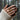 Close-up of 925 silver abstract merger ring worn on hand holding a textured dark mug in a scenic forest setting