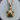 Close-up of the 3D sea turtle pendant resting on a natural wooden log slice highlighting the polished gold vermeil finish