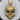 Close-up of the luxury angel skull pendant showcasing ornate gothic metalwork resting on a wooden slice