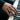 Close-up of men's mountain climber ring worn on hand playing a piano highlighting the two-tone silver and gold finish
