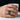 Torii Gate signet ring worn on a man's hand holding a white cup showing the striking gold and oxidized silver contrast
