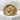 High-angle view of sculpted wolf signet ring featuring pine tree relief work resting on white textured stone