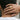 Model wearing the gold-tone Byzantine Orthodox cross signet ring on finger held against back of neck