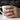 Jormungandr Serpent Ring, oxidized silver, worn on model hand holding mug