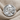 Benjamin Franklin Ring, polished silver, front view on textured fabric