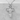 Corpus Christi Crucifix Pendant, polished silver, front view against grey stone
