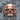 Baroque Fanged Skull Ring, oxidized silver finish, frontal view resting on dark stone