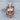 Middle Finger Skull Pendant, rose gold, front view on wood