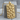 Skull wall dog tag pendant, gold vermeil, front view on wood block