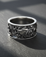 Side angle of handcrafted silver ring showing intricate fish scales and wave relief design