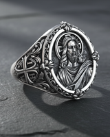Front view of 925 sterling silver Jesus Christ ring with halo and floral border on dark stone background