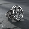 Front view of 925 sterling silver Jesus Christ ring with halo and floral border on dark stone background