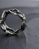 Side view of 925 sterling silver lovers unity ring showing detailed muscular sculpture and oxidized finish