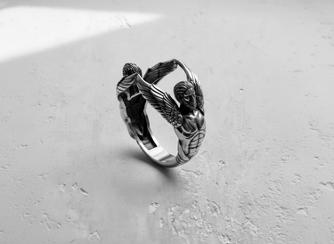 Angled view of handcrafted silver winged ring showing intricate muscle and feather detailing