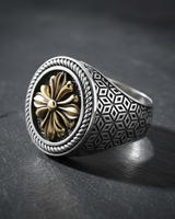 Two-tone 925 sterling silver signet ring with gold floral cross and rope bezel on dark background