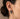 Model wearing silver angel earring on ear showing size and sculptural drop design of the praying cherub