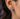 Side profile view of silver devil earring worn on ear showing lever back clasp and intricate detailing