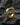 14K gold vermeil geometric hoop earring with faceted design on dark stone background
