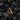 14K gold vermeil textured triangle earring displayed on black volcanic rocks