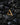 14K gold vermeil textured triangle earring displayed on black volcanic rocks